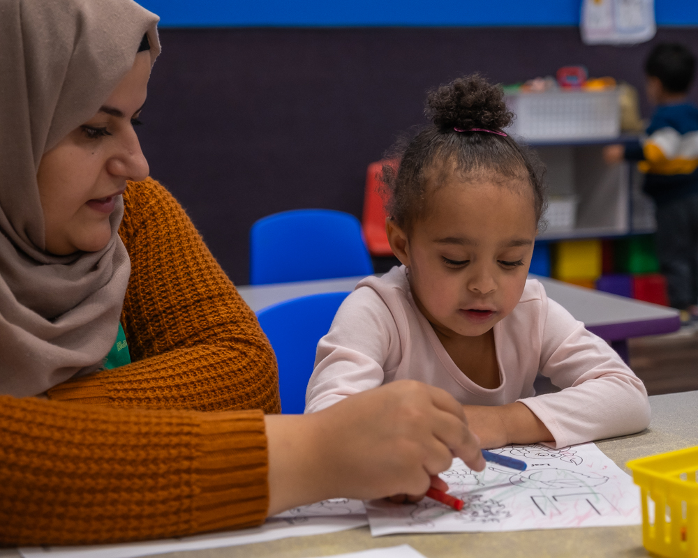 toddler working with teacher to learn